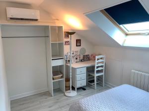 1 dormitorio con cama, escritorio y tragaluz en Les chambrées de Sergine, en Jonchery