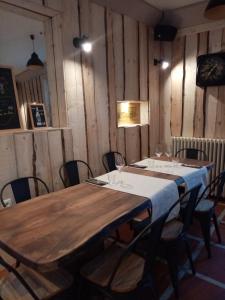 - une table dans une pièce dotée de murs en bois et de chaises dans l'établissement Auberge Buissonniere, à Gresse-en-Vercors