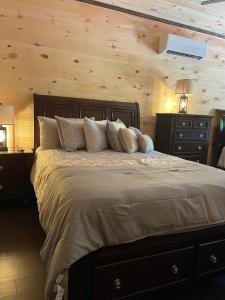 a bedroom with a large bed with wooden walls at Chalet Village- Amazing Mountain Views - Piney Butt Place in Gatlinburg