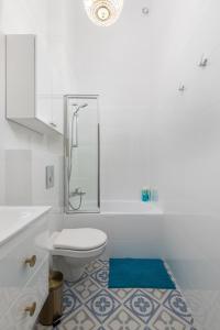 a white bathroom with a toilet and a shower at Apartament Królewska by Your Freedom in Warsaw