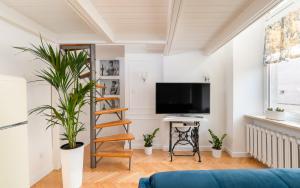 a living room with a staircase and a flat screen tv at Apartament Królewska by Your Freedom in Warsaw