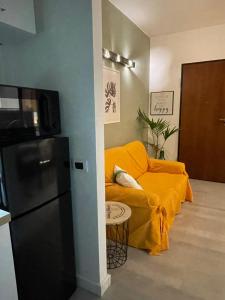 a living room with a yellow couch and a refrigerator at Casa Lilla&Fabry Olbia in Olbia