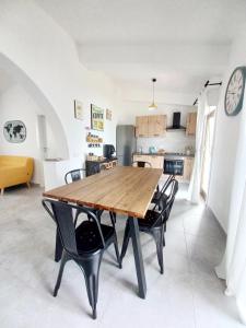 una cucina e una sala da pranzo con tavolo e sedie in legno di Sea Sound House a SantʼAmbrogio