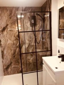 e bagno con doccia e parete in marmo. di Little Wren Cartmel Couples Retreat a Cartmel