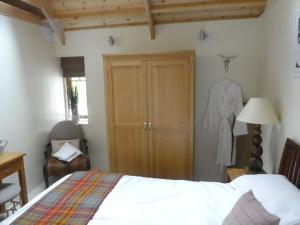 una camera con letto, armadio e cassettiera di Wildcat Lodge a Boat of Garten