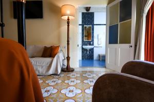 a living room with a couch and a lamp at Maria Giovanna Guest House in Marsalforn
