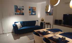 salon z niebieską kanapą i stołem w obiekcie SunsetCroatia w Novalji