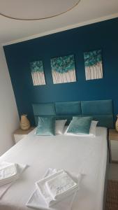 een slaapkamer met een wit bed en een blauwe muur bij SunsetCroatia in Novalja