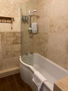 a bathroom with a bath tub and a shower at Old Hall Hotel Hope in Hope