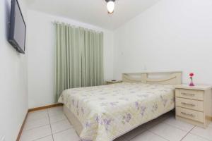 1 dormitorio con 1 cama, vestidor y TV en Ilhas Cayman, en Bombinhas