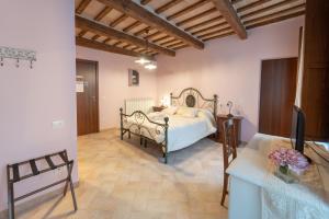 ein Schlafzimmer mit einem Bett und einem TV in einem Zimmer in der Unterkunft Albergo La Loggia di San Martino in Gualdo Tadino