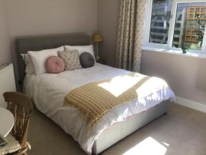 a bedroom with a bed with pillows and a window at The Costrel in Tenbury