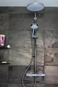 a shower in a bathroom with a stone wall at The Costrel in Tenbury