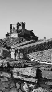 uma foto a preto e branco de um castelo numa colina em La Lagareta de Olivia em Trevejo