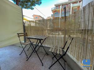 2 Stühle und ein Tisch auf einem Balkon mit einem Zaun in der Unterkunft Florian Home in Pescara