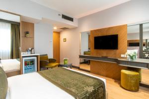 a hotel room with a bed and a flat screen tv at Oran Hotel in Istanbul