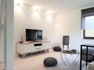 a living room with a television on a white wall at Ferienwohnung Königsquellenpark in Bad Wildungen