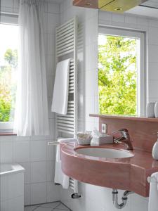 baño con lavabo y ventana en Parkhotel en Bad Wünnenberg