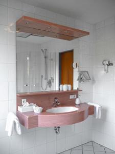 a bathroom with a sink and a mirror at Parkhotel in Bad Wünnenberg