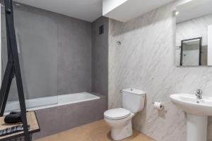 a bathroom with a toilet and a sink and a bath tub at Apartamentos Venecia in Lloret de Mar +37 photos