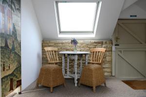 a room with three chairs and a table with a window at Mulberry Cottage in Cheltenham