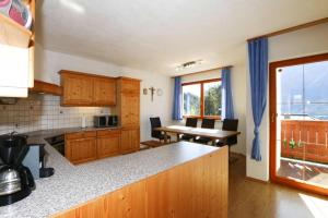 a kitchen with wooden cabinets and a table and a dining room at Ferienhaus Jäger in Oetz