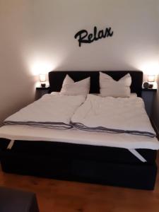 Una cama con sábanas blancas y almohadas. en Aschenputtel, en Altenau