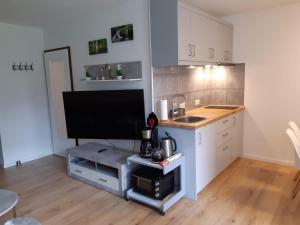 a kitchen with white cabinets and a tv on a counter at Aschenputtel in Altenau
