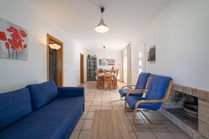 ein Wohnzimmer mit einem blauen Sofa und 2 Stühlen in der Unterkunft Holiday Home Dakota in L'Escala