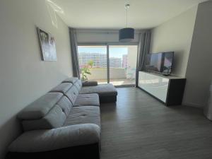 a living room with a couch and a flat screen tv at Pool view apartment in Funchal
