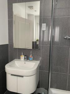 a bathroom with a white sink and a mirror at Harford en-suite Rooms in Lymington