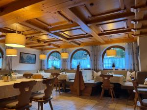 a restaurant with tables and chairs and windows at Hotel Pension Siggi in Sankt Leonhard im Pitztal