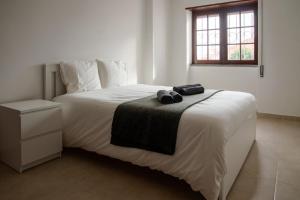a bedroom with a large white bed with a window at Cascais Center Apartment - 500 m from the beach in Cascais