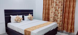 a bedroom with a bed with white sheets and pillows at Suvarna Elite - Premium Apartment Hotel in Mysore