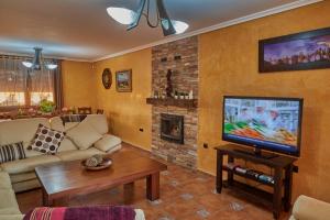 Televízia a/alebo spoločenská miestnosť v ubytovaní Villa El Rosal del Pozo
