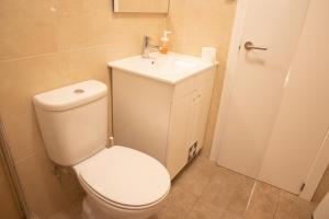a bathroom with a white toilet and a sink at Spacious and Sunny Apartment - 10 min from the sea in Estoril