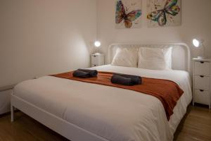 a bedroom with a large bed with two towels on it at Spacious and Sunny Apartment - 10 min from the sea in Estoril