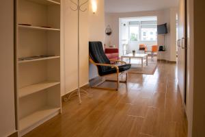 a hallway with a chair and a living room at Spacious and Sunny Apartment - 10 min from the sea in Estoril