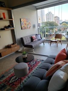 uma sala de estar com um sofá e uma grande janela em Moderno Oca Moema em São Paulo