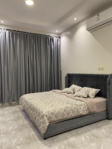 a bedroom with a large bed with a curtain at شاليه العبير in Buraydah