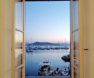 a window view of a marina with boats in the water at Aegina Port Apt 4 in Egina +21 photos