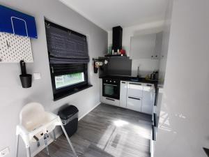 a small kitchen with white cabinets and a window at Zum Waldblick in Funfseen
