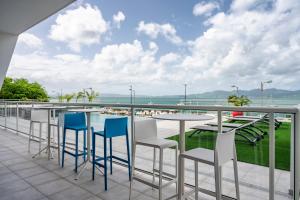 d'un balcon avec des chaises et des tables offrant une vue sur l'océan. dans l'établissement Résidence Hôtelière Poséidon Caraïbes, à Fort-de-France