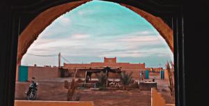 uma vista para um deserto com um edifício e uma moto em Gite GAMRA em Merzouga