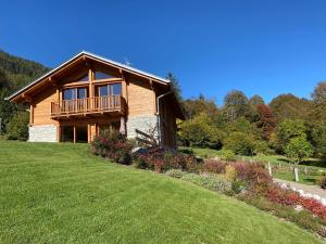 una baita di tronchi su una collina con cortile di B & B Chalet Plan a Strembo