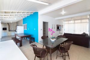 a dining room and living room with a table and chairs at CASA COM PISCINA EM MORRINHOS - RUA HORTÊNCIA in Bombinhas