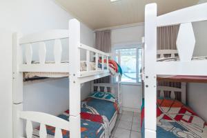 a room with two bunk beds and a bed at CASA COM PISCINA EM MORRINHOS - RUA HORTÊNCIA in Bombinhas +9 photos