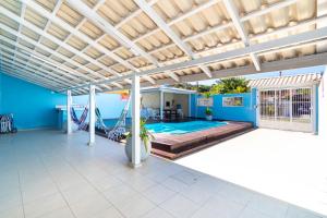 an outdoor patio with a hammock and a pool at CASA COM PISCINA EM MORRINHOS - RUA HORTÊNCIA in Bombinhas