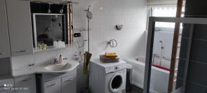 ein Badezimmer mit einer Waschmaschine und einem Waschbecken in der Unterkunft Feriendomizil Familie Finke in Weener