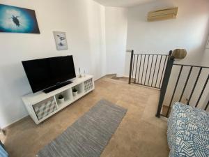 A television and/or entertainment centre at Amazing duplex with large terrace and sea views